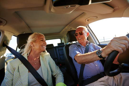 Love, road trip and smile of old couple in car together for retirement holiday, travel or vacation. Adventure, break or journey with senior people in vehicle for drive, transportation or wellness - Powered by Adobe