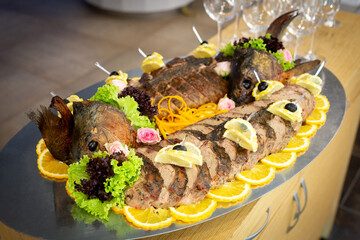 A dish of fish divided into pieces and cooked with lemon and vegetables.