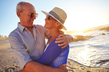 Old couple, hug and smile by ocean with love for connection, commitment and summer vacation. Married, elderly people and embrace at beach with sunglasses for holiday, support and bonding together.