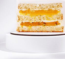 Delicious layered cake with orange filling displayed on a white pedestal