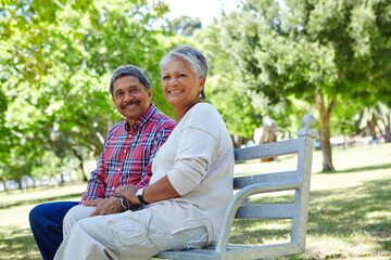 Naklejka premium Senior couple, portrait or bonding with park bench for sightseeing, comfort or outdoor fresh air. Elderly, man and woman with smile or love for holiday, weekend or retirement together in nature