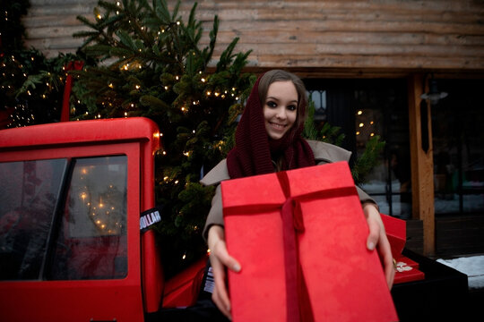 woman in red dress with christmas gift