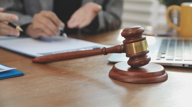 lawyer and client looking at each other while discussing papers in office
