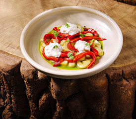 Colorful roasted peppers and creamy cheese on a rustic wooden table