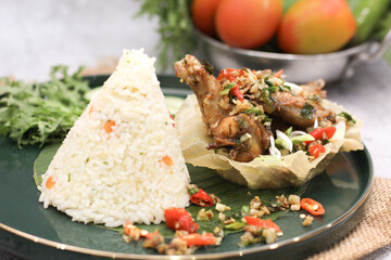 Indonesian Spicy Fried Chicken with Cone Rice on Green Plate