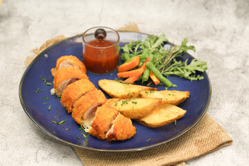 Chicken Cordon Bleu with Potato Wedges and Vegetables on Blue Plate