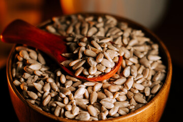 Peeled roasted sunflower seeds in a bowl with a wooden spoon for serving