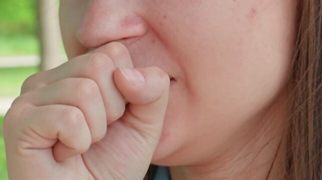 woman coughs outdoors, woman showing respiratory distress outside, closeup of woman experiencing cough in park, woman exhibiting coughing and concern in park setting with natural background