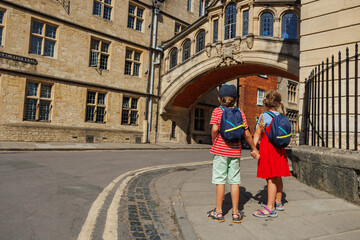 Two kids look towards a notable Bridge of Sighs, Oxford, England
