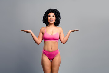Young woman in pink bikini smiling with arms outstretched showcasing confidence beauty and body...