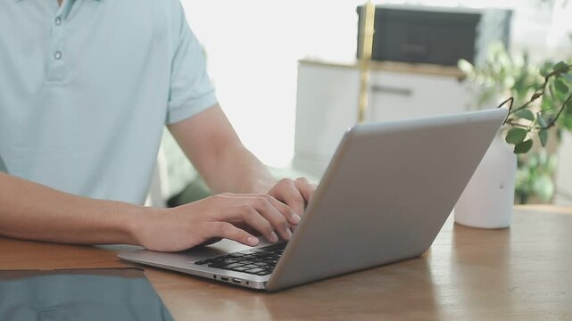 Two financial accountants analysing business spreadsheets on laptop computer, sitting at office desk, looking through paper documents, using calculator working with databases, checking excel tables