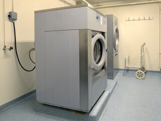 Shared apartment building laundry room with washing machine