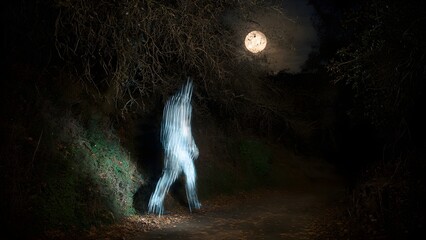 Ghostly figure walking on a dark spooky forest path under a full moon