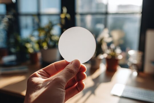 High quality photo of a hand holding a blank white circular sticker
