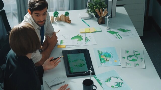 Professional business man presenting sustainable idea to manager by using tablet display ESG environmental social governance. Smart manager working together planning to use clean energy. Alimentation.