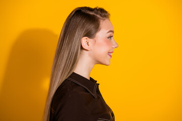 Profile of a young stylish woman with blonde hair smiling against a bold yellow background for fashion lifestyle advertising