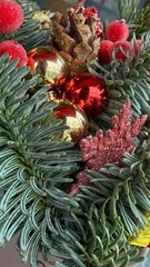 Fototapeta premium Close-up of Festive Christmas Arrangement with Frosted Berries, Cones, and Ornaments