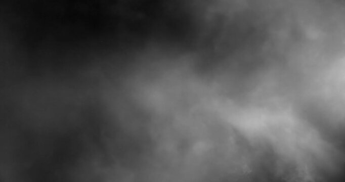 Dense cinematic smoke rolls across a dark background, drifting in layered plumes that create deep atmosphere and moody texture. Perfect as a practical VFX element or atmospheric overlay.