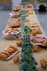 table decorated and set with tapas and appetizers, sandwiches, ham, empanadas, chips...