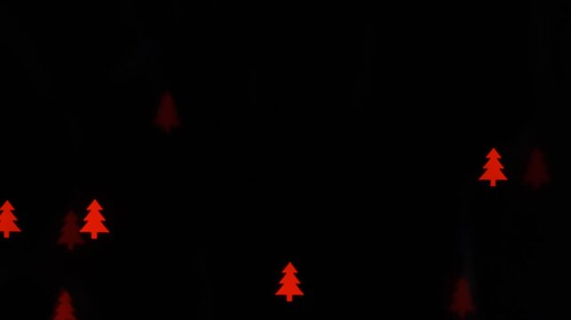 Small red tree shapes flicker randomly against a black background, creating a minimal festive abstract effect with soft glowing light.