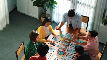 Creative team putting hand together while brainstorm about Ux Ui design mobile phone interface. People planning strategy start up project while making stack of hands at meeting room. Convocation.