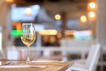 a glass of cold white wine and serving in the restaurant