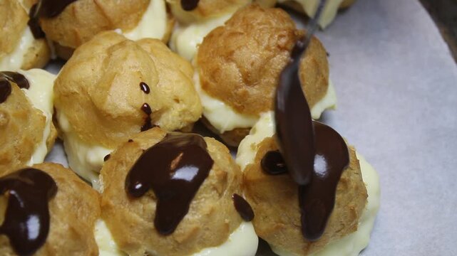 Spread liquid chocolate over an eclair or princess donut