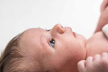Newborn baby observing world with blue eyes