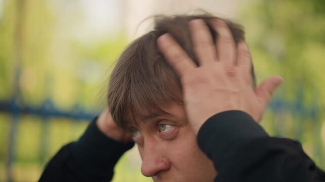 man adjusting hair before meeting, man carefully groomed himself in park for professionalism, individual meticulously prepares and stabilizes his appearance ahead of formal discussion