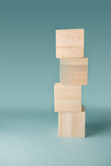 Stacked wooden blocks on a soft blue background showcasing balance and creativity in design