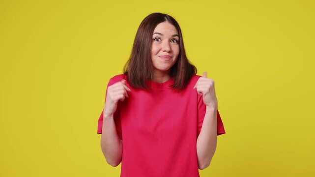 Hesitant indecisive fun shy young woman wear pink t-shirt casual clothes feels doubtful spreading hands say oops ouch oh omg i am so sorry isolated on plain yellow color background. Lifestyle concept