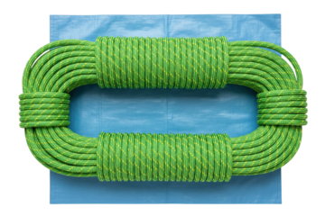 Coiled green climbing rope placed on blue plastic tarp on a transparent background
