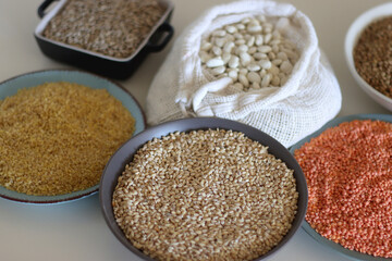 Bowls and bags full of various healthy grains and legumes. Selective focus.