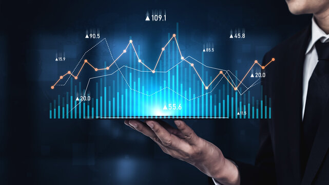 A businessman holds a digital graph displaying rising data points representing financial trends and analytics in a sleek, modern corporate environment. Scalp