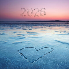 lovely frozen heart in the ice with 2026 - winter sunset at lake