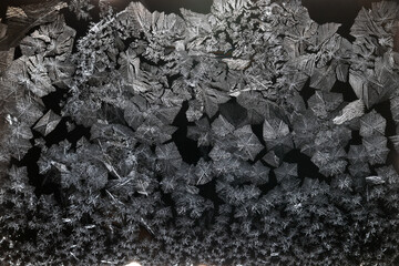 Ice crystals freezing on a black background, abstract winter photo surface