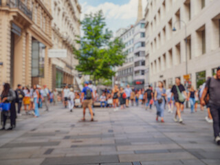 Crowd of anonymous people walking on busy city street