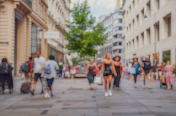 Crowd of anonymous people walking on busy city street