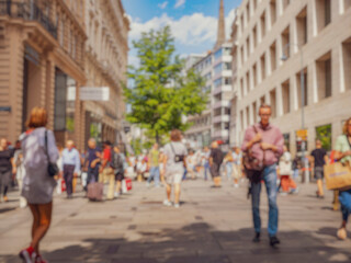 Crowd of anonymous people walking on busy city street