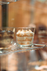 Elegant close-up of a layered Napoleon (mille-feuille) served in a glass — creamy custard, crisp puff pastry and powdered sugar. Great for dessert, recipe, and menu visuals.