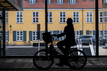 Urban architecture in Copenhagen creates deep shadow and contrast around transport corridors and green mobility lanes, expressing environment, sustainability and long term climate action
