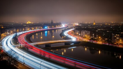 Fototapeta premium Long exposure light trails of traffic moving fast along a curved road in a city at night