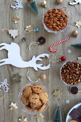 Various Christmas decorations, cookies, chocolate and nuts on wooden background. Flat lay.