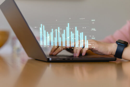 hands typing on a laptop with virtual analytics chart overlay, representing business data analysis, digital marketing insights financial performance tracking.