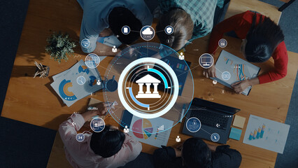 A business team collaborates in a modern office, analyzing financial charts while utilizing digital icons that symbolize data-driven decision-making and strategic planning. Trope
