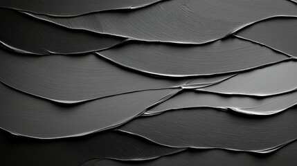 Close-up of a textured black surface with layered brushstrokes, creating a dynamic and abstract design. The lighting highlights the texture.