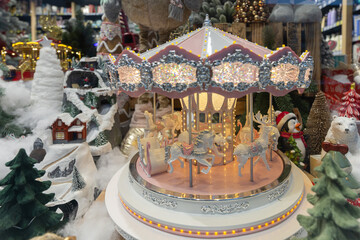 Illuminated Christmas carousel in winter shop window