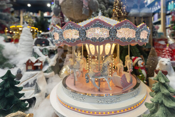 Illuminated Christmas carousel in winter shop window