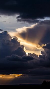 A breathtaking cinematic view of a dramatic sky as golden sunlight powerfully pierces through ominous, dark, and heavy storm clouds. Majestic crepuscular rays fan out, illuminating the atmospheric sce