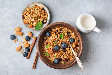 Fototapeta premium Homemade crunchy oat honey granola with raisins and nuts in wooden bowl, rich in fiber breakfast cereals